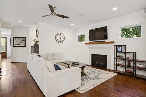 a living room with furniture a flat screen tv and a fireplace