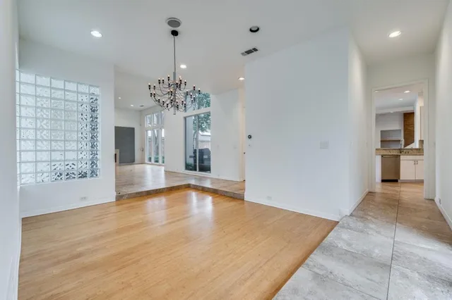 a view of a room with a chandelier and wooden floor