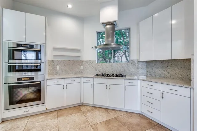 a kitchen with granite countertop white cabinets stainless steel appliances and a sink