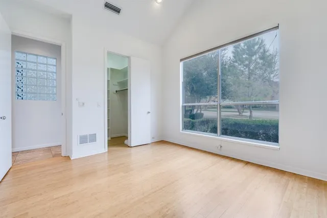 a view of an empty room with wooden floor