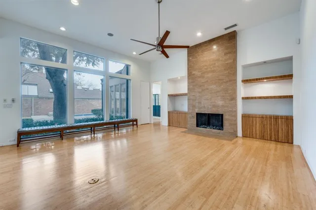 a view of empty room with wooden floor and fireplace