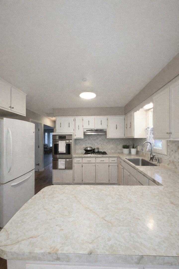 7332 Beloit Avenue Bridgeview, IL 60455 - Photo 12 of 21 a kitchen with stainless steel appliances granite countertop a refrigerator sink and white cabinets