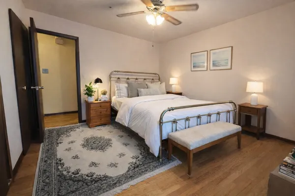 a bedroom with a bed table and dresser