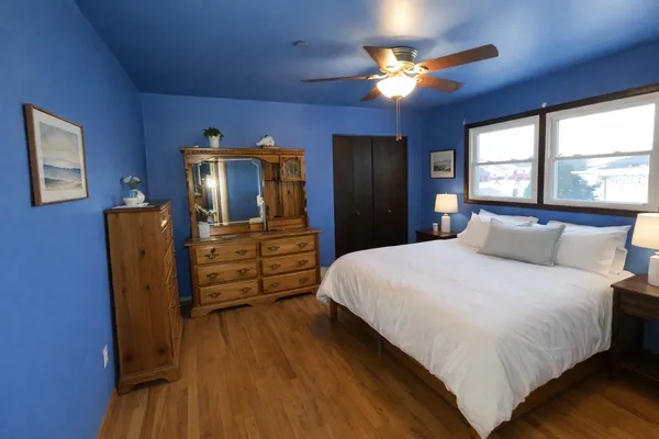 a bedroom with bed and wooden floor