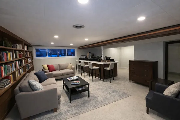 a living room with furniture a rug and a book shelf