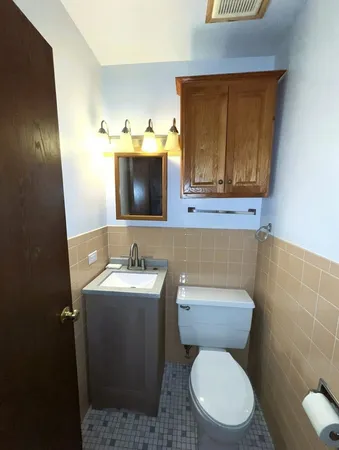 a bathroom with a toilet sink and mirror