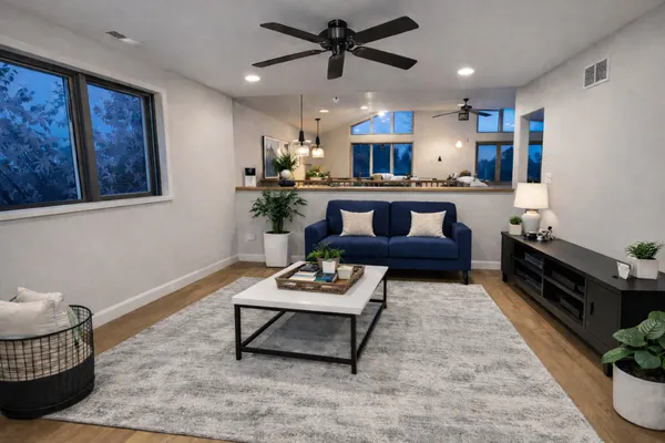 a living room with furniture and a wooden floor