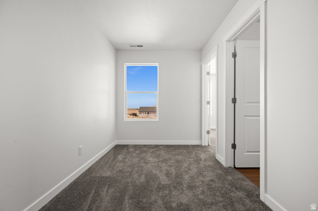 1554 Pheasant Road Eagle Mountain, UT 84005 - Photo 22 of 29 Empty room with dark colored carpet and baseboards