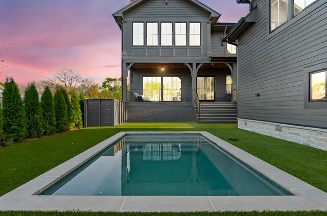 a patio with table and chairs and potted plants