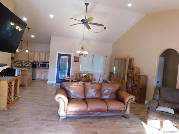 a living room with furniture a flat screen tv and kitchen view