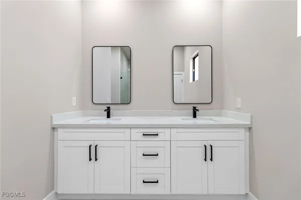 a bathroom with double sink and two mirror