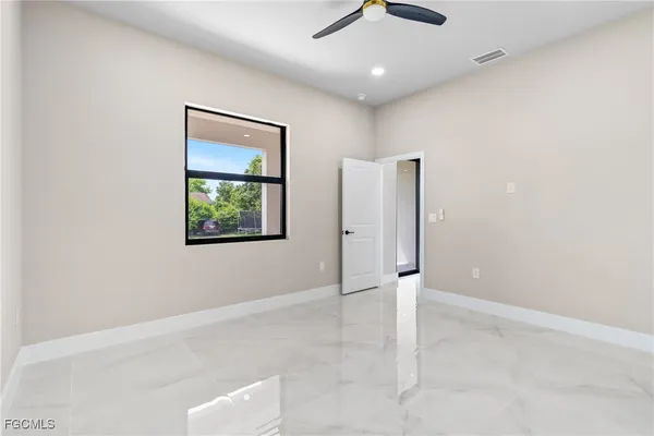 an empty room with a ceiling fan and window