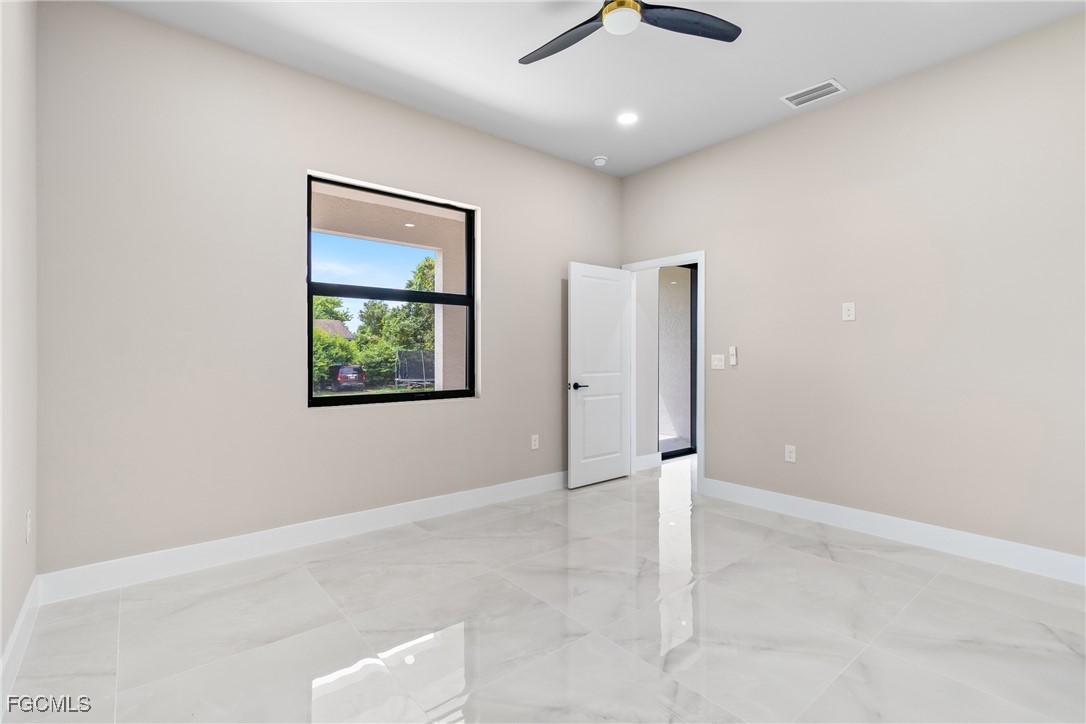 2809 25th Street Southwest Lehigh Acres, FL 33976 - Photo 16 of 36 an empty room with a ceiling fan and window