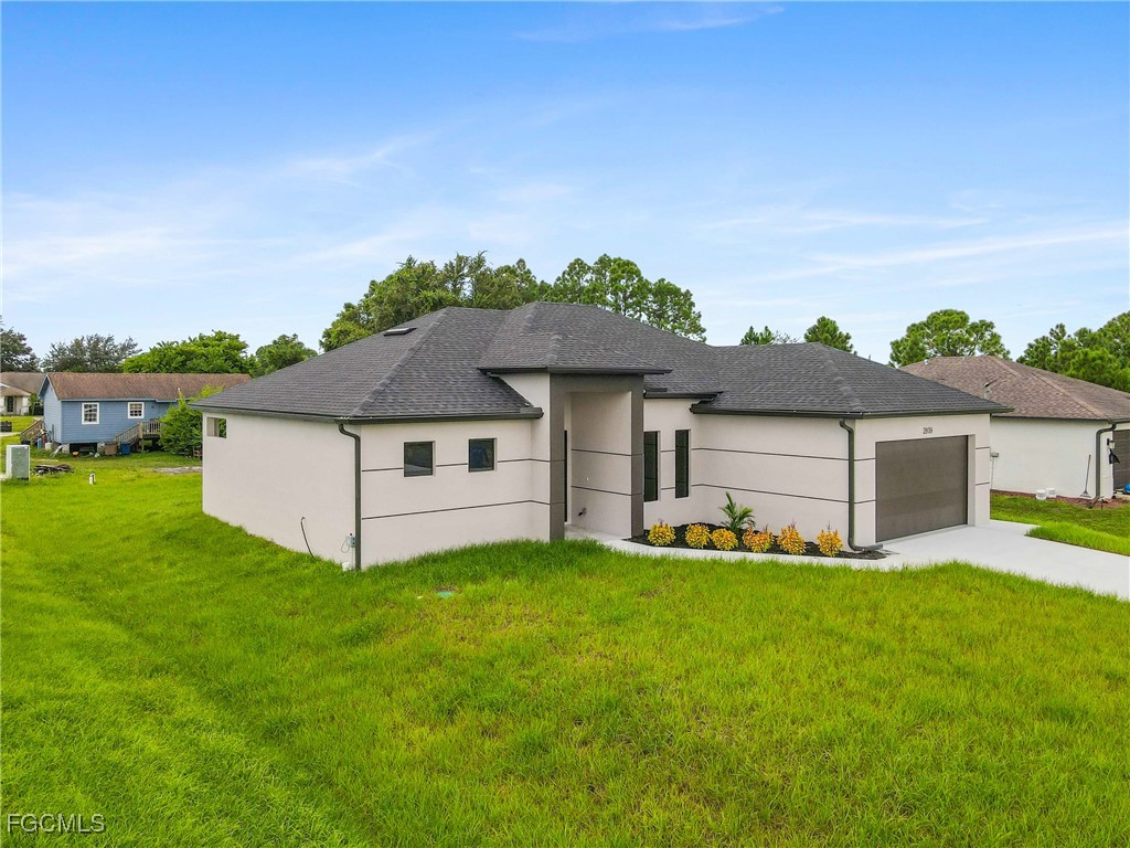 2809 25th Street Southwest Lehigh Acres, FL 33976 - Photo 2 of 36 a front view of house with yard and garage