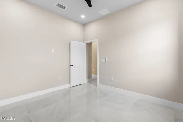 an empty room with windows and fan