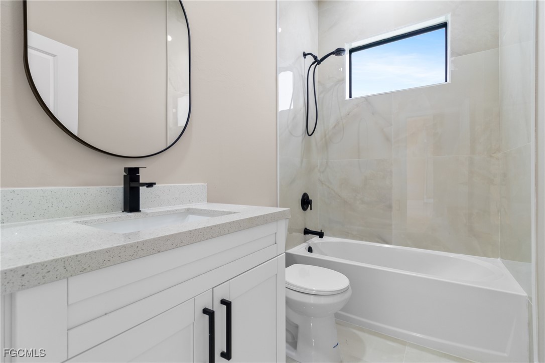 2809 25th Street Southwest Lehigh Acres, FL 33976 - Photo 24 of 36 a bathroom with a sink a toilet and a mirror