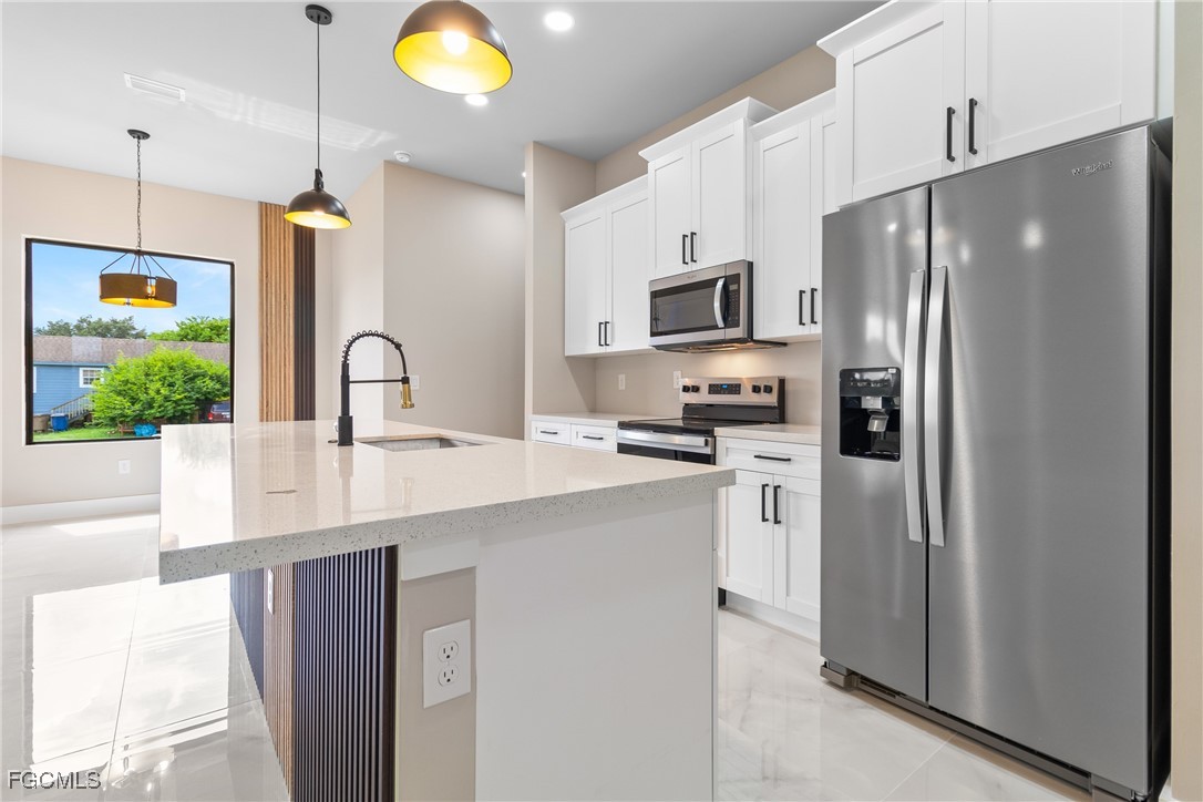 2809 25th Street Southwest Lehigh Acres, FL 33976 - Photo 30 of 36 a kitchen with stainless steel appliances a refrigerator sink and stove