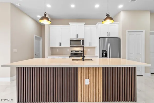 a kitchen with stainless steel appliances a refrigerator and a stove top oven