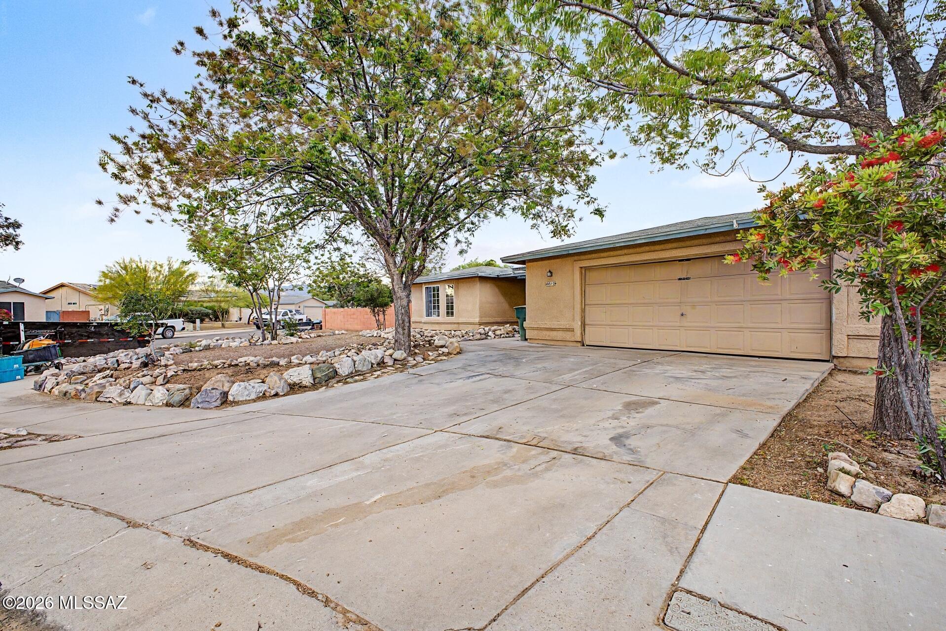 9810 East Stonehaven Way Tucson, AZ 85747 - Photo 5 of 27 a front view of a house with a yard and garage