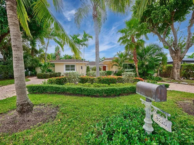 a view of a house with a yard and potted plants