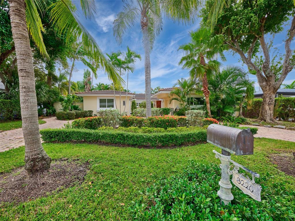 a view of a house with a yard and potted plants