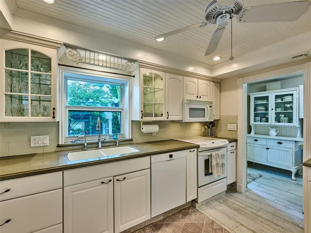a kitchen with a sink window and cabinets