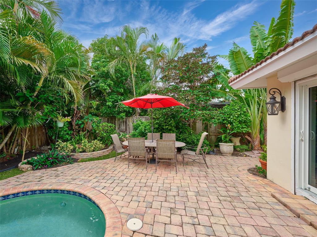 3220 Oleander Way Lauderdale-by-the-Sea, FL 33062 - Photo 37 of 50 a backyard of a house with table and chairs