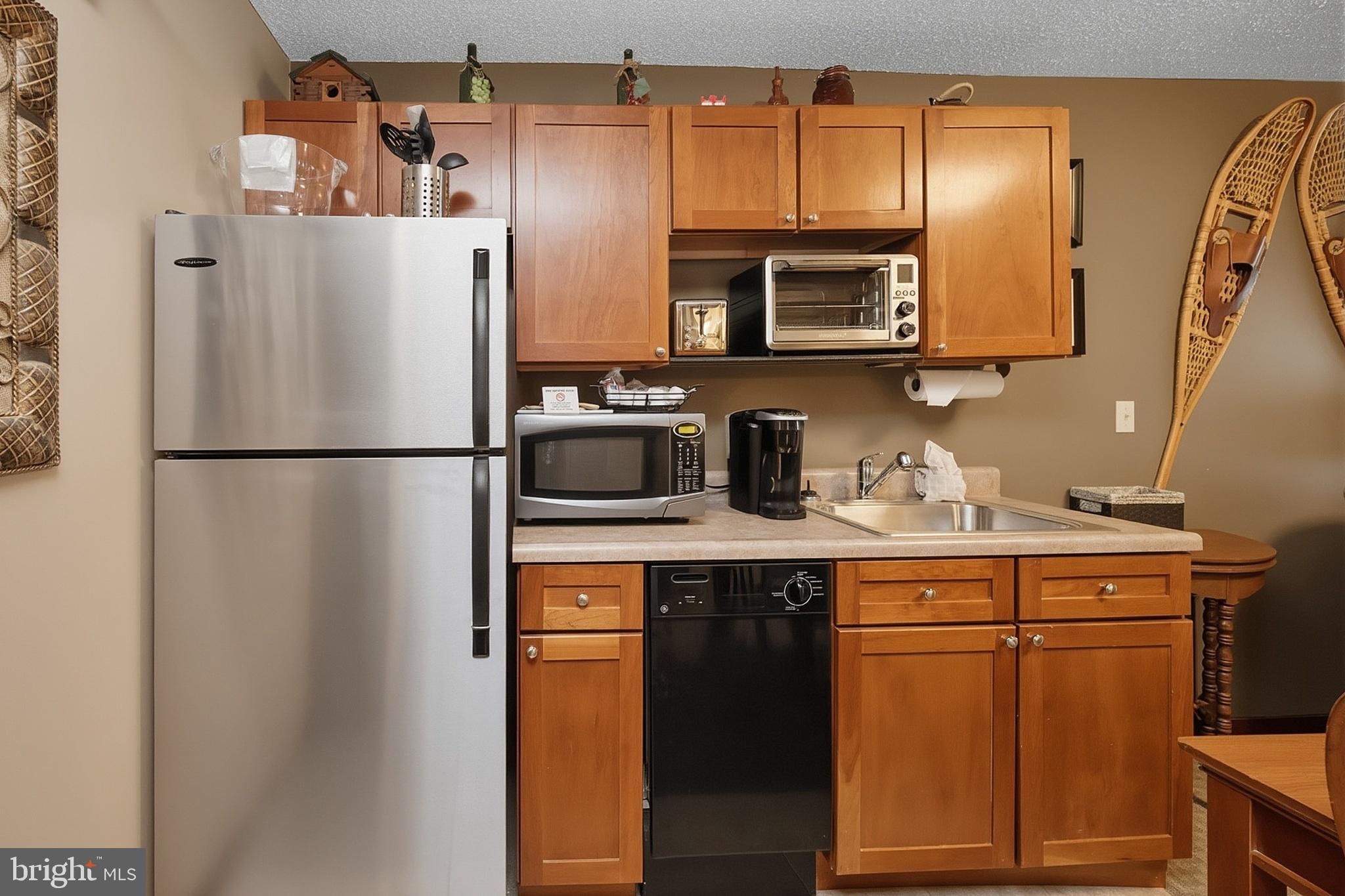 565 Glendale Road, Unit 208A Oakland, MD 21550 - Photo 9 of 51 a kitchen with stainless steel appliances granite countertop a refrigerator a microwave a sink and cabinets