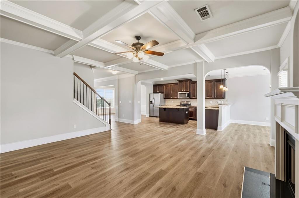268 Clubhouse Crossing Acworth, GA 30101 - Photo 22 of 48 a view of a kitchen with a stove cabinets wooden floor and a ceiling fan