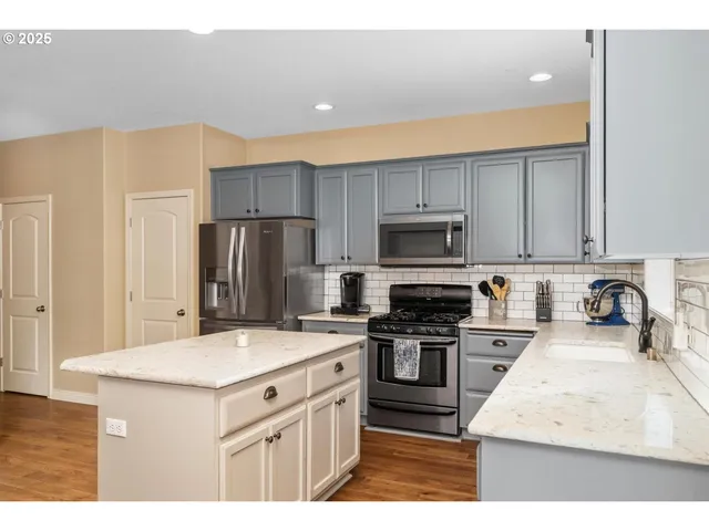 a kitchen with a sink a stove a refrigerator and a microwave