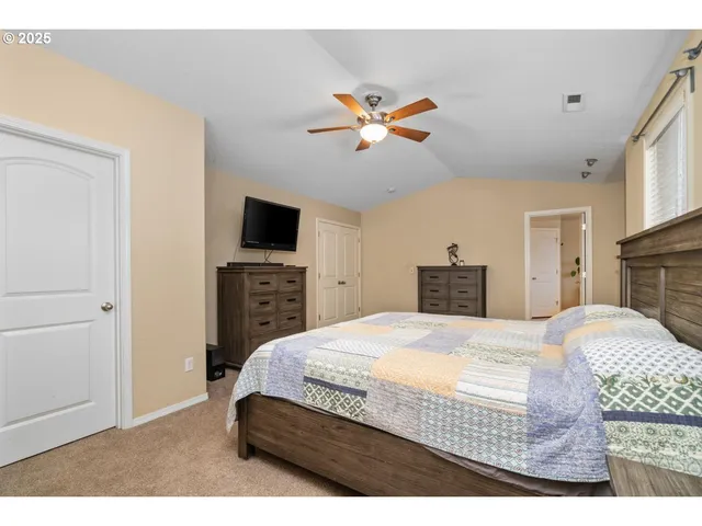 a bedroom with a bed a dresser and a fireplace