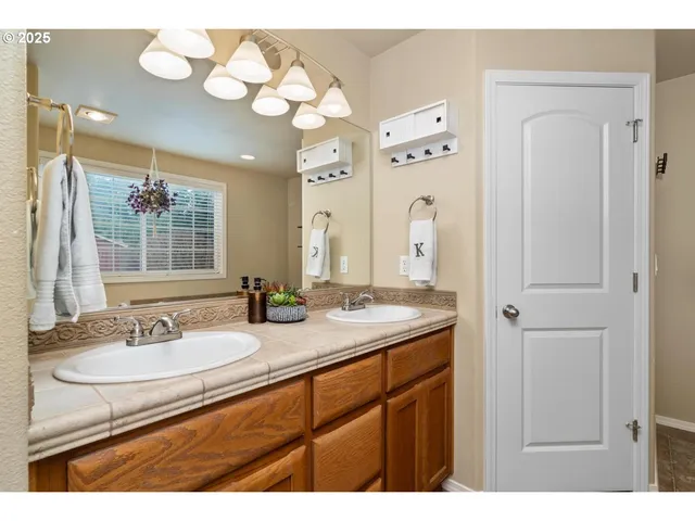 a bathroom with a granite countertop sink a large mirror and a shower