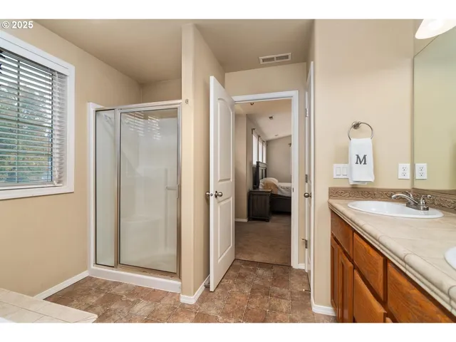 a bathroom with a sink a mirror and a shower