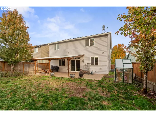 a backyard of a house with table and chairs