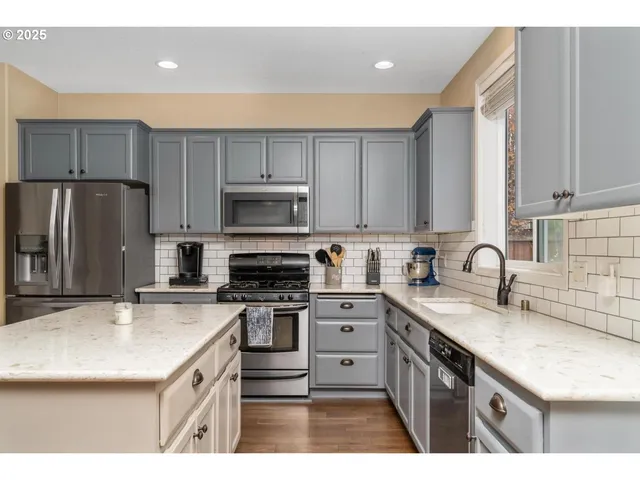 a kitchen with kitchen island granite countertop a sink stainless steel appliances and cabinets
