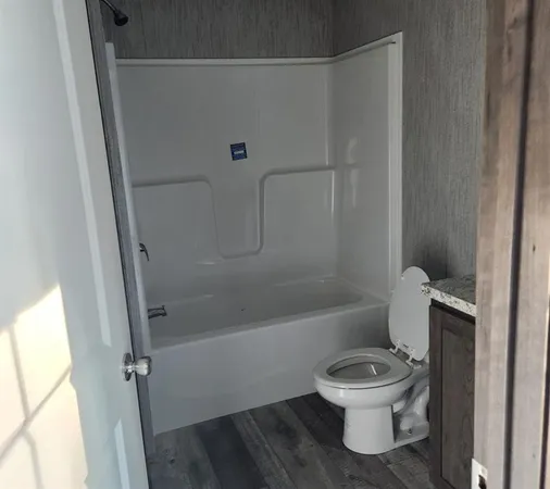a white toilet sitting next to a bath tub
