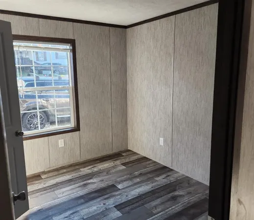 a view of a livingroom with wooden floor and a window