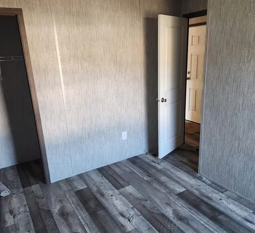 an empty room with wooden floor and a window