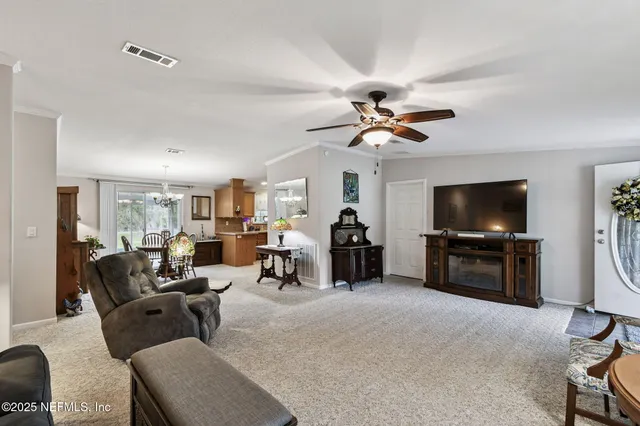 a bedroom with a bed a couch and a flat tv screen on the dresser