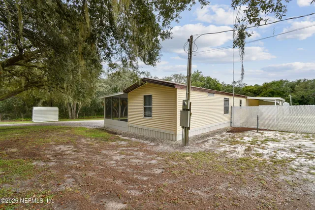 a aerial view of a house with a yard and lake view