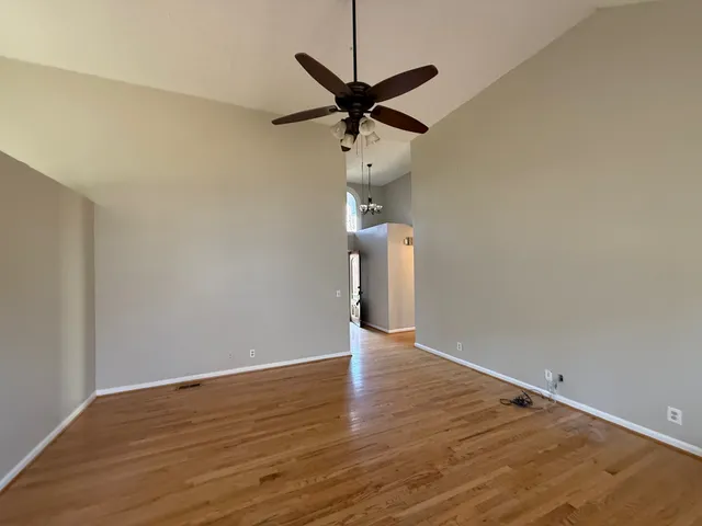 a view of a room with wooden floor and a ceiling fan