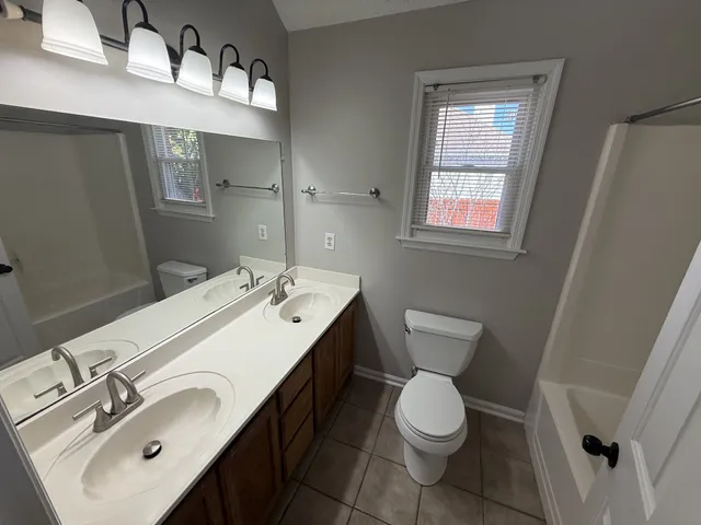 a bathroom with a toilet sink and mirror