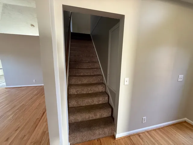 a view of a hallway with wooden floor and entryway
