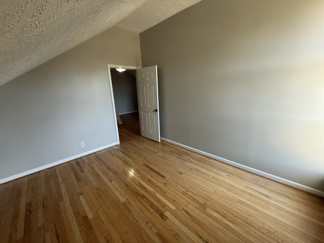 a view of a room with wooden floor and white walls