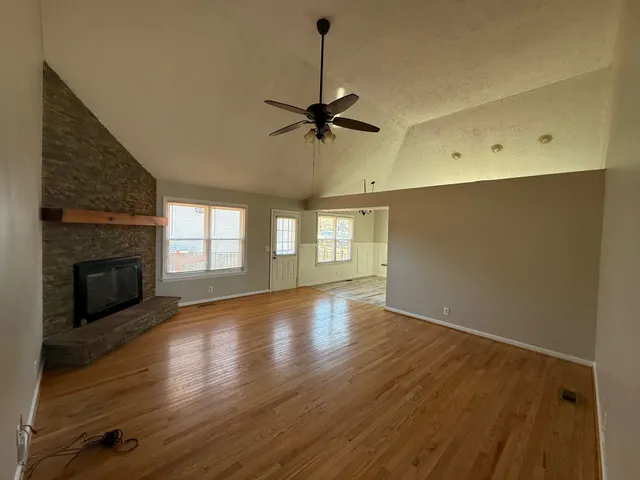 a view of empty room with wooden floor and fireplace