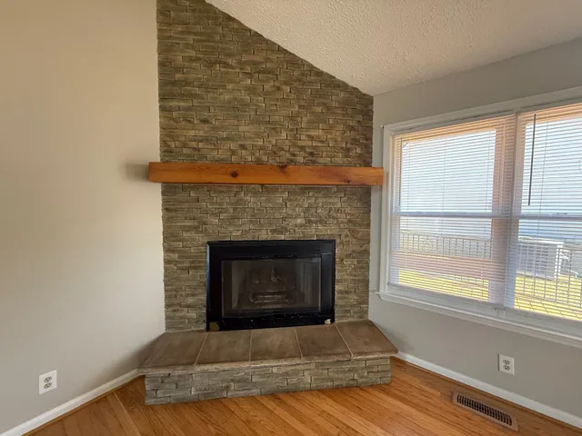 a living room with a fireplace and windows