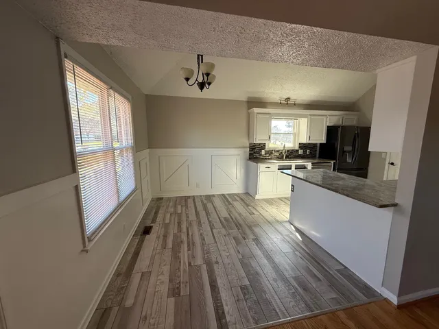 a kitchen with a sink wooden floor and stainless steel appliances