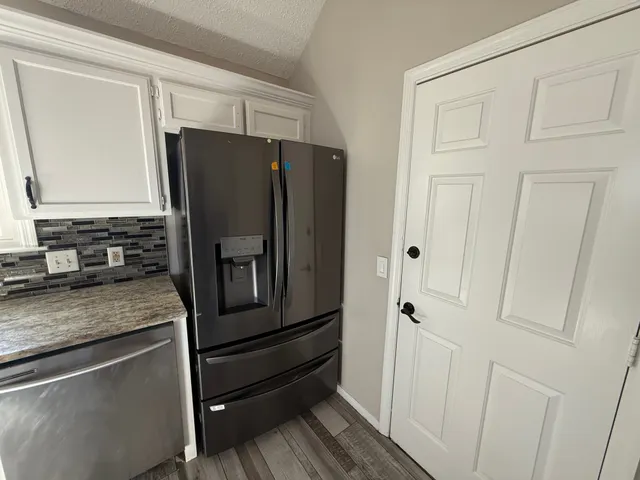 a kitchen with stainless steel appliances granite countertop a refrigerator and cabinets