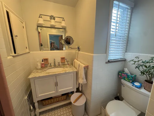 a bathroom with a toilet sink and mirror