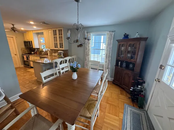 a view of a dining room with furniture a chandelier and wooden floor